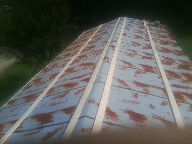 Rusted metal roof panels with new wood purlins before replacement — Storm Damage Roof Repair in Chepachet by Roofing Brothers