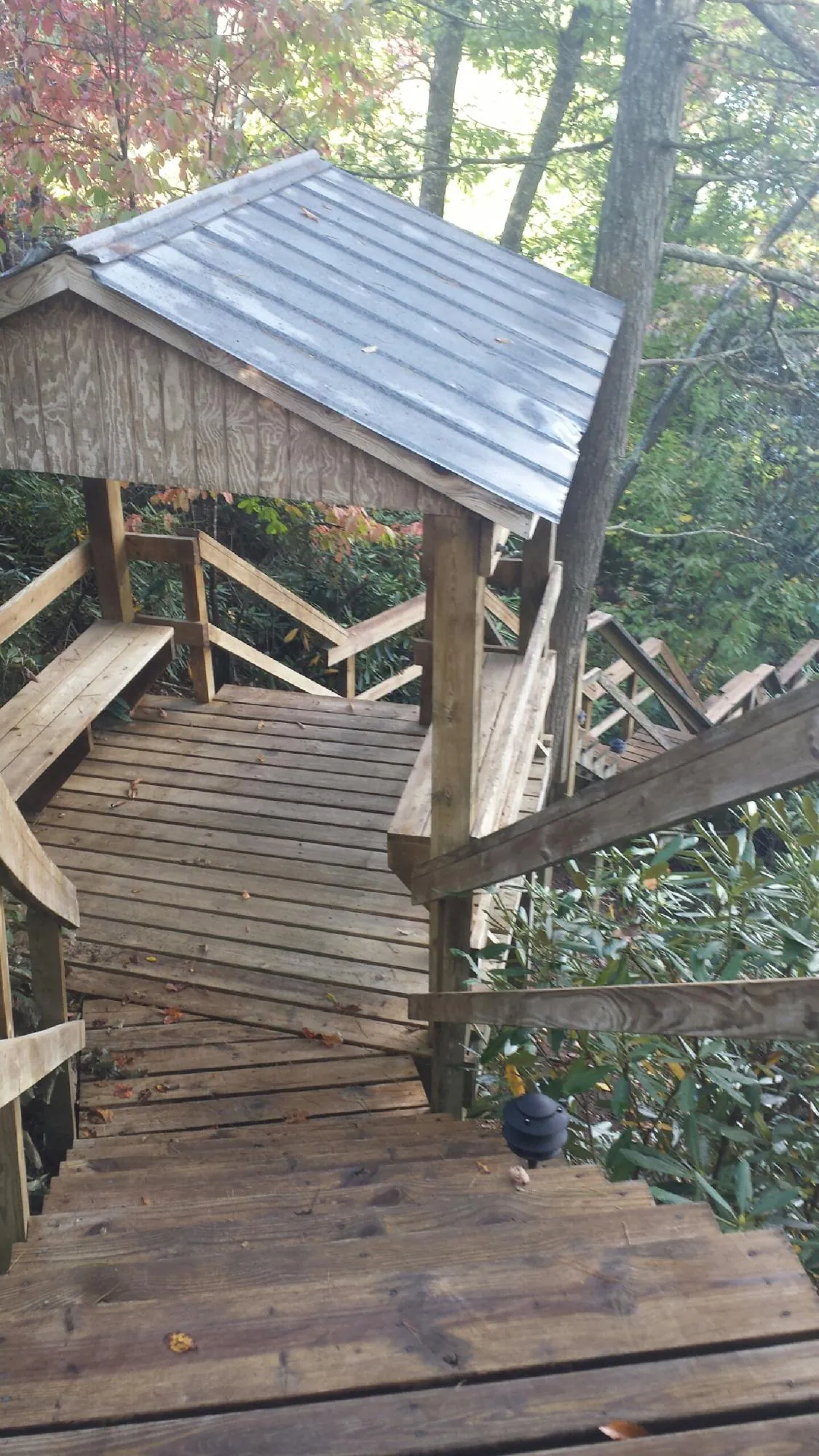 Metal roofed shelter over wooden steps on a wooded walkway — Skylight Repair & Installation work by our crew in Chepachet